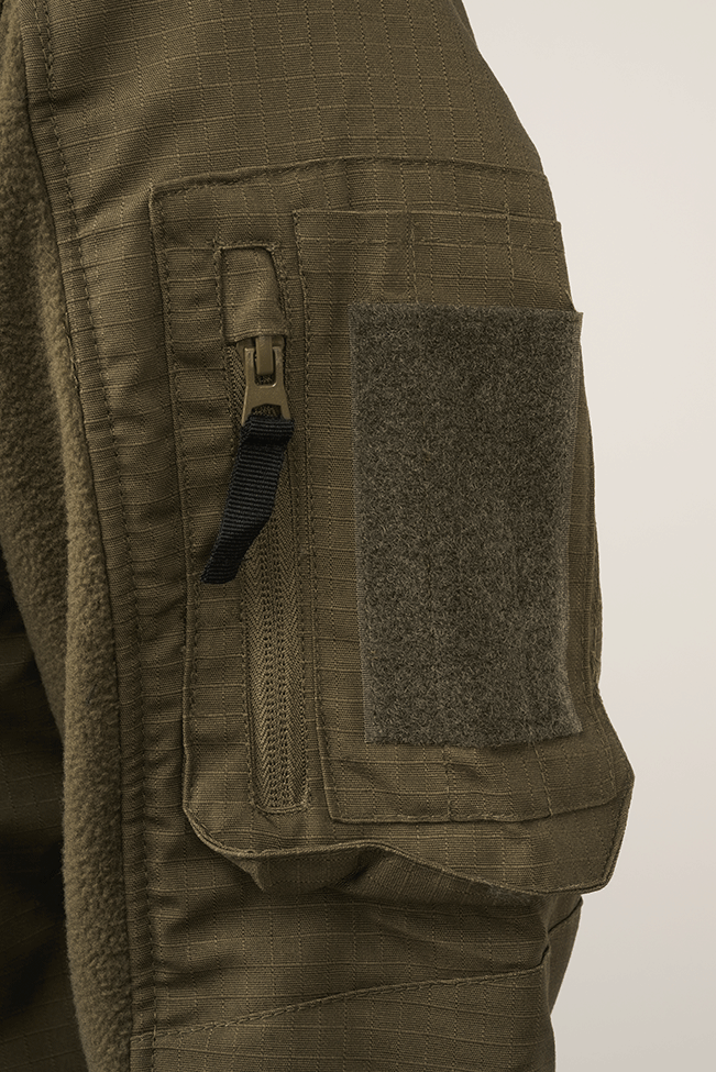 `Detailaufnahme einer taktischen Jacke mit Ärmeltasche und Klettfläche`

