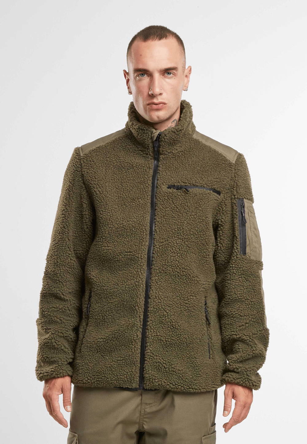 `Model trägt taktische Teddyfleece Jacke in Oliv mit Reißverschlusstaschen`
