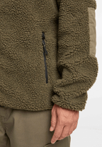 `Detailaufnahme einer taktischen Teddyfleece Jacke in Oliv mit Reißverschlusstasche`
