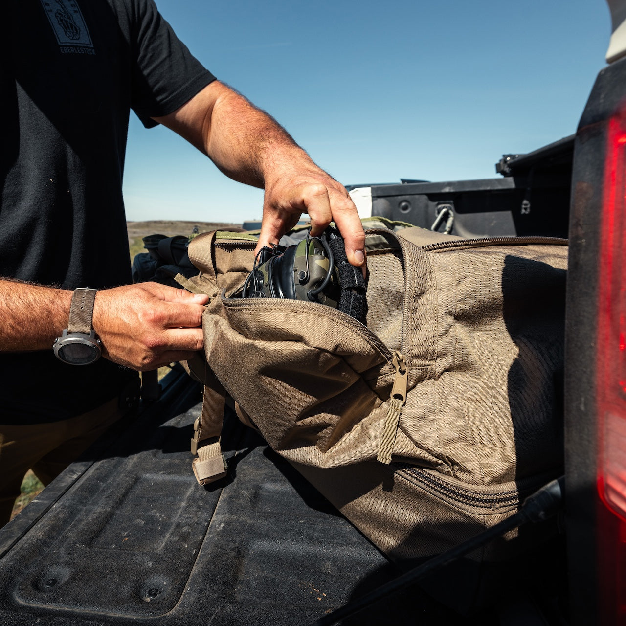`Eberlestock Tactical Duffel Bag auf Pickup-Ladefläche – robuste Outdoor- und Range-Tasche mit Schnellzugriff für Gehörschutz und Ausrüstung`

