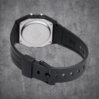 `Rückansicht der schwarzen CASIO F-91W-1YEG Armbanduhr mit Resin-Armband auf grauem Betonhintergrund`
