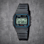 Schwarze CASIO F-91W-1YEG Digitaluhr mit Resin-Armband in Frontansicht auf grauem Betonhintergrund
